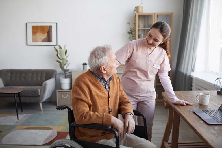 Staff member reviews a resident’s labeled medications and electronic medication record at a care station.